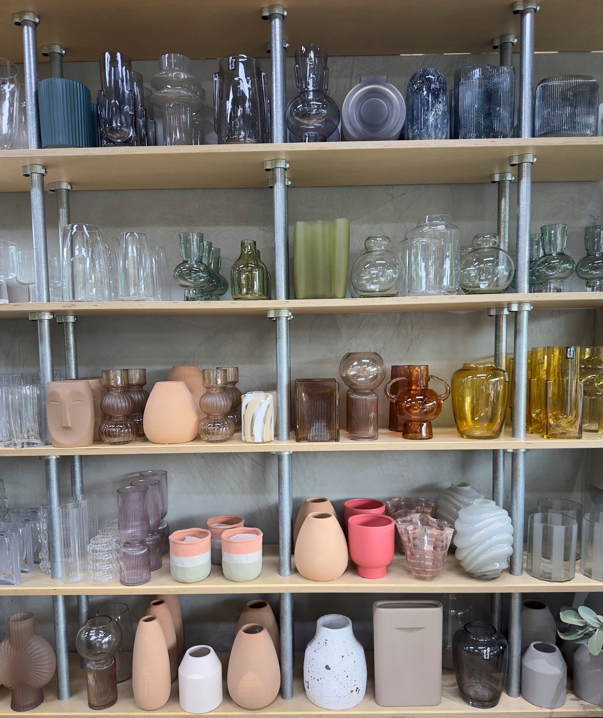 Shelves with various glass and ceramic vases and containers.